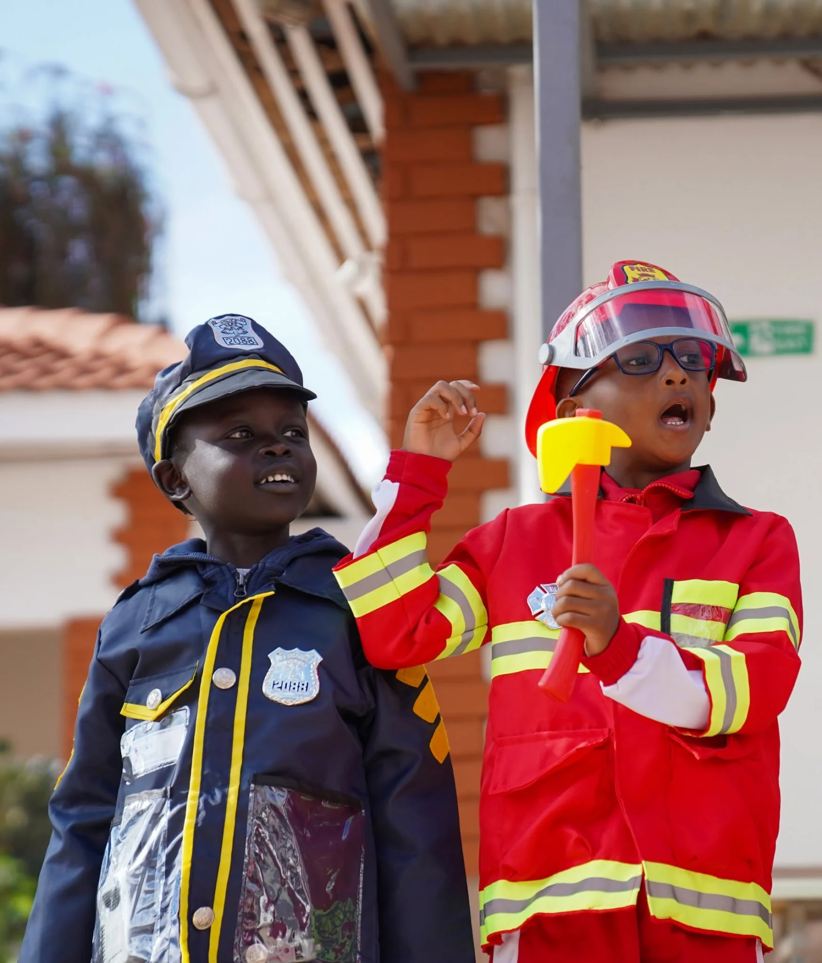 A young firefighter and police officer during Fire and Safety Week at LIS Lenana